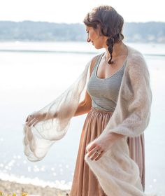 a woman in a dress and shawl by the water