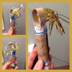 a hand holding a rolled up paper tube with writing on it and some ribbons attached to it