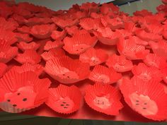 red paper cups with holes in them are lined up on a counter top, ready to be used as decorations