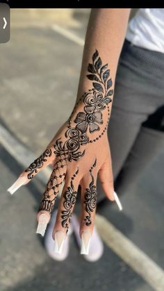 a woman's hand with henna tattoos on it