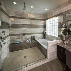 a bathroom with marble counter tops and wooden flooring, along with a walk in shower