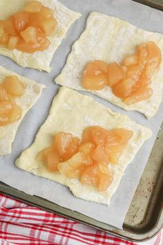 four square pieces of food sitting on top of a pan