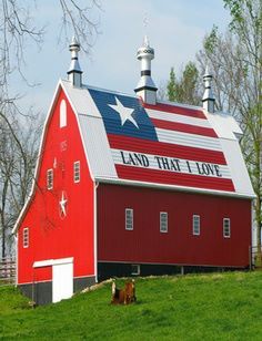 a red barn with an american flag painted on it's side and the words land that i love