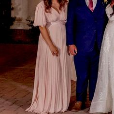 two women and a man standing next to each other in formal wear, posing for the camera