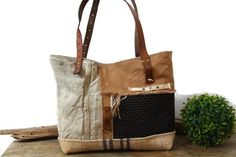 a handbag sitting on top of a wooden table next to a potted plant