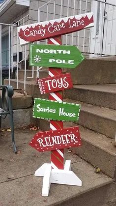 a sign that says candy cane lane and north pole toys is on top of some steps