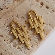 Chic Gold Linear Metal Earrings, Gold Geometric Metal Jewelry, Trendy Gold Linear Earrings, Modern Geometric Gold Hoop Earrings, Modern Gold Geometric Hoop Earrings, Trendy Gold Dangle Linear Earrings, Trendy Gold-tone Dangle Earrings, Trendy Gold Geometric Earrings, Modern Geometric Gold Earrings