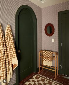 a bathroom with green doors and checkered towels hanging on the door handle, next to a chair