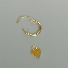 A PAIR of 12 mm sterling silver hoops. Comes with a delicate heart charm. Charm can be used with a neck chain or bracelet. Dimensions: Hoops: 12 x 1 mm Heart: 6 mm Drop length 19.5mm Weight: 0.85 gm These earrings are made of 925 hypoallergenic sterling silver dipped in gold. Price listed is for ONE PAIR Can be packaged in a gift box. I can include a personal message from you if needed You are welcome to contact me at... bhavnakwintra1956@gmail.com For more beautiful pieces from my shop, please Minimalist Hoop Earrings With Heart Charm, Minimalist Hoop Earrings For Valentine's Day, Heart-shaped Minimalist Hoop Earrings, Tarnish Resistant, Minimalist Hoop Jewelry With Heart Charm, Minimalist Heart-shaped Tarnish Resistant Hoop Earrings, Minimalist Heart-shaped Tarnish-resistant Hoop Earrings, Nickel-free Heart-shaped Minimalist Hoop Earrings, Minimalist Hoop Earrings With Heart Charm For Anniversary, Minimalist Nickel-free Heart Hoop Earrings