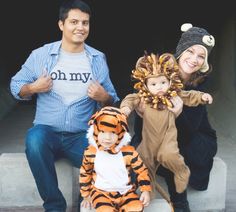 a man and woman are posing for pictures with their children dressed up as tiger costumes