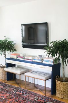 a living room filled with furniture and a flat screen tv mounted to the side of a wall