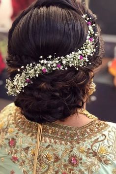 the back of a woman's head with flowers in her hair, wearing a tiara