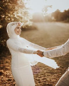 a bride and groom holding hands in the sun