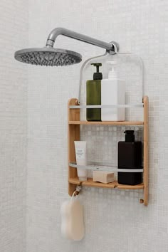 a shower head with soap, lotion and shampoo on it