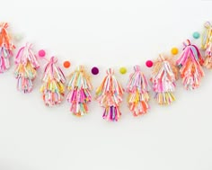 colorful tasselled garland with pom - poms on white background