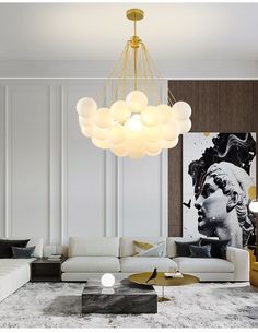 a living room with white couches and a chandelier hanging from the ceiling