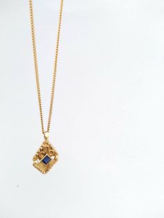 "14k solid yellow gold boho-chic pendant necklace set with a sapphire. This dainty necklace is made of 14k yellow gold and has a diamond-shaped solid gold pendant. The pendant has an elaborate ethnic-boho design and is set with a shiny blue sapphire. This 14k solid gold necklace is beautiful and chic and will upgrade any outfit you'll wear. It is perfect for everyday use but will also stand out in any high-class occasion. You can wear it as a single item or layered with other necklaces for a tot 14k Gold Square Pendant Necklace With Birthstone, Delicate Yellow Gold Necklace With Square Pendant, Delicate Yellow Gold Square Pendant Necklace, Handmade Yellow Gold Necklace With Square Pendant, Handmade Yellow Gold Sapphire Jewelry, Gold Sapphire Necklaces For Gift, Gold Sapphire Necklace For Gifting, Gold Sapphire Jewelry Gift, Gold Sapphire Necklace For Gift