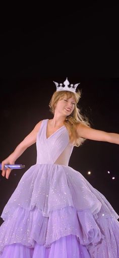 a woman in a dress with a tiara on her head and arms outstretched out