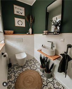 a white toilet sitting next to a sink in a bathroom