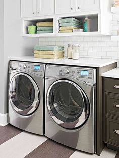 a washer and dryer in a small room with white tile flooring on the walls