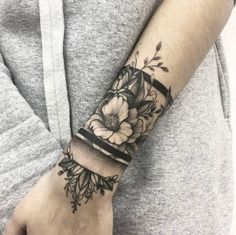 a woman's arm with flowers on it, and a black and white tattoo