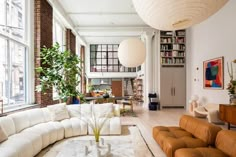 a living room filled with lots of furniture and large windows next to a white rug