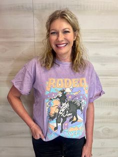 Wild West Rodeo Lilac Graphic Tee Get ready to wrangle some serious style with our Wild West Rodeo Lilac Graphic Tee! Featuring a playful graphic and comfortable fit, this tee is perfect for roaming the ranch or hitting the town. Saddle up and add some fun to your wardrobe! Giddy up!