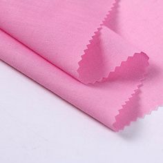 the pink fabric is folded on top of each other