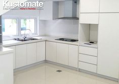 an empty kitchen with white cabinets and counter tops is pictured in this image from the front view