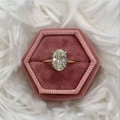 an oval diamond ring in a velvet box