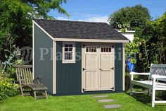 a garden shed with two chairs in the grass