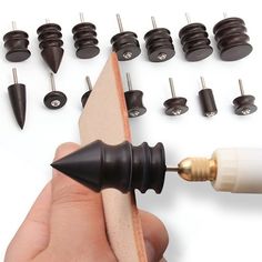 a person is holding a small tool in front of some screws and other tools