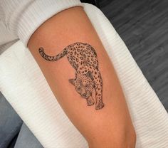 a person with a tattoo on their arm that has a cheetah on it