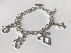 a silver bracelet with charms on it and an i love you sign in the middle