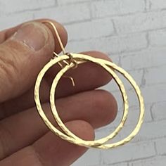 These gorgeous Handmade Hammered Gold Hoops  are a timeless classic! They go with everything and easily transmissible safer from day tonight wear.  Made from 14k Gold filled square wire, the hoops have been hammered to catch the light and add a little glamour!  The earwires are handmade and compliment the hoops without distracting.  The Hoops is a little over 1.25 inches and the earring will hang 2 inches from your piercing. Made especially for you personally by me in my studio. Should you have Classic Handmade Round Hoop Earrings, Anniversary Hammered Hoop Earrings, Hoop Dangle Earrings, Earrings Large, Hammered Gold, Large Earrings, Gold Hoops, Jewelry Earrings Hoops, Gold Hoop