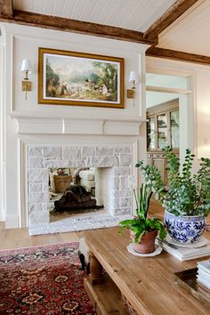 a living room filled with furniture and a fire place under a painting on the wall