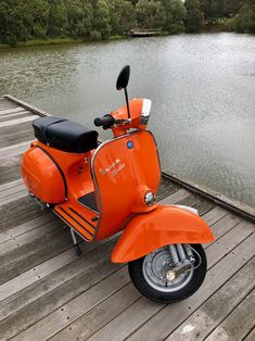 an orange scooter is parked on the dock