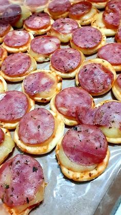 small pizzas with pepperoni and ham on them are ready to be baked in the oven