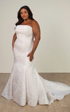 a woman in a white wedding dress posing for the camera with her hands on her hips