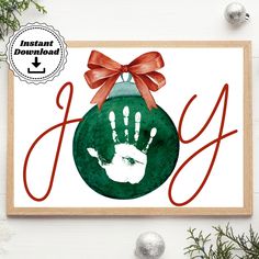 a christmas ornament with a hand print on it and a bow around the top