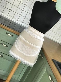 a mannequin in a kitchen wearing a white lace skirt