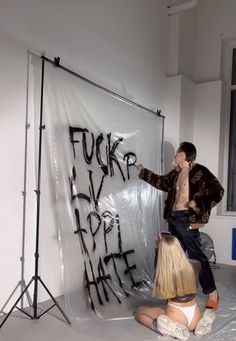 a man standing next to a woman in front of a white board with writing on it