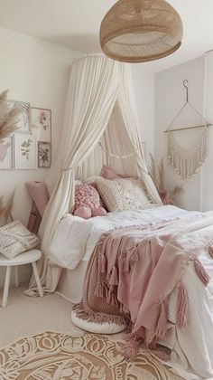 a bedroom with a canopy bed and pink pillows on the floor, along with rugs