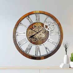 a large wooden clock with gears on it's face is shown in front of a white wall