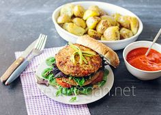 two plates with food on them next to a bowl of potatoes