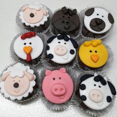 twelve cupcakes decorated with farm animals on top of each other in the shape of sheep, cow, pig and chicken