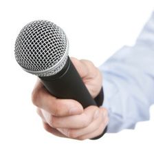 a man holding a microphone up to the side with his hand on top of it