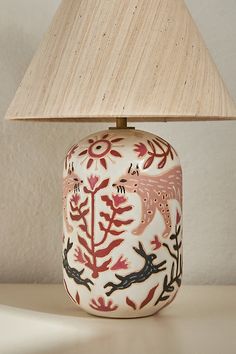 a lamp that is sitting on top of a table next to a light fixture with a wooden shade over it