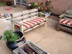 a wooden bench sitting on top of a patio next to potted plants and containers