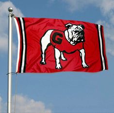 a flag with a bulldog on it flying in the air next to a cloudy blue sky